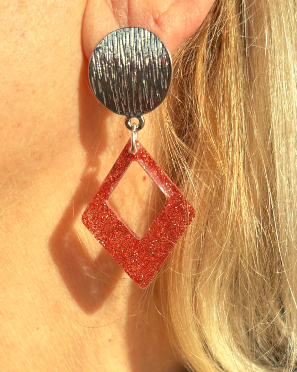 "Boucle d'oreilles pailletes - FIESTA Orange Losange fabriqué en résine UV avec intégration de paillettes de couleur orange. Clou d'oreilles ronds striés en zamak"